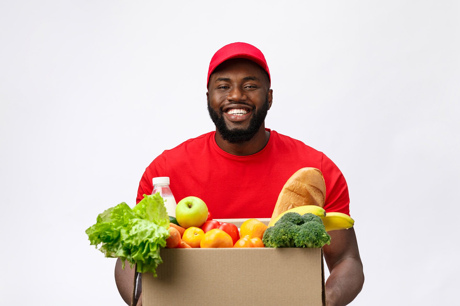 Delivery Concept - Handsome African American delivery man carrying package box of grocery food and drink from store. Isolated on Grey studio Background. Copy Space.